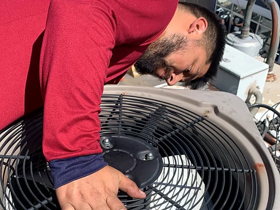 Técnico revisando el ventilador de un condensador en azotea